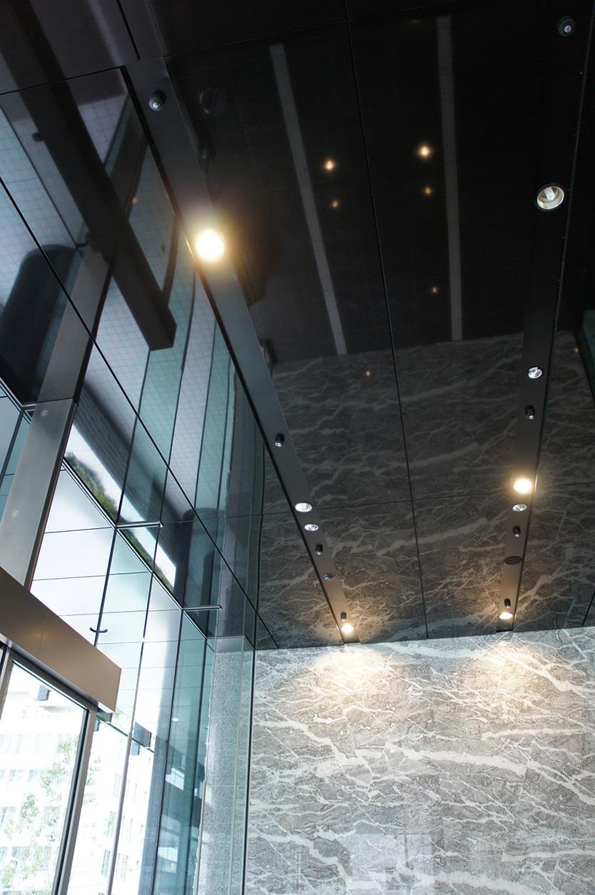 ビルの風除室の天井にミラーのようなアルミパネルが使用された